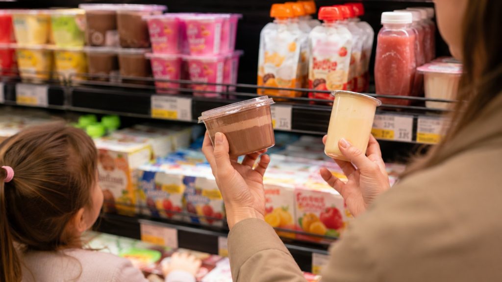 Półka deserków dziecięcych to strefa, w której marketing gra najostrzej: uśmiechnięte krówki, „porcja mleka" w hasłach i formaty w sam raz do małej rączki. Wrzesień — sezon kompletowania plecaków — po